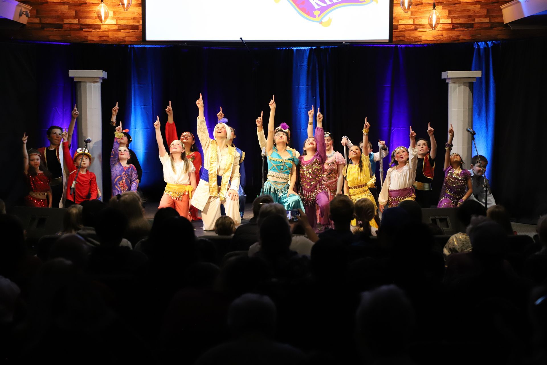 A group of people are dancing on a stage in front of a crowd.