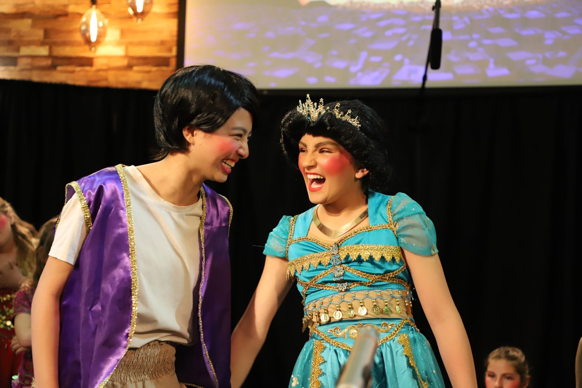 A boy and a girl are standing next to each other on a stage.