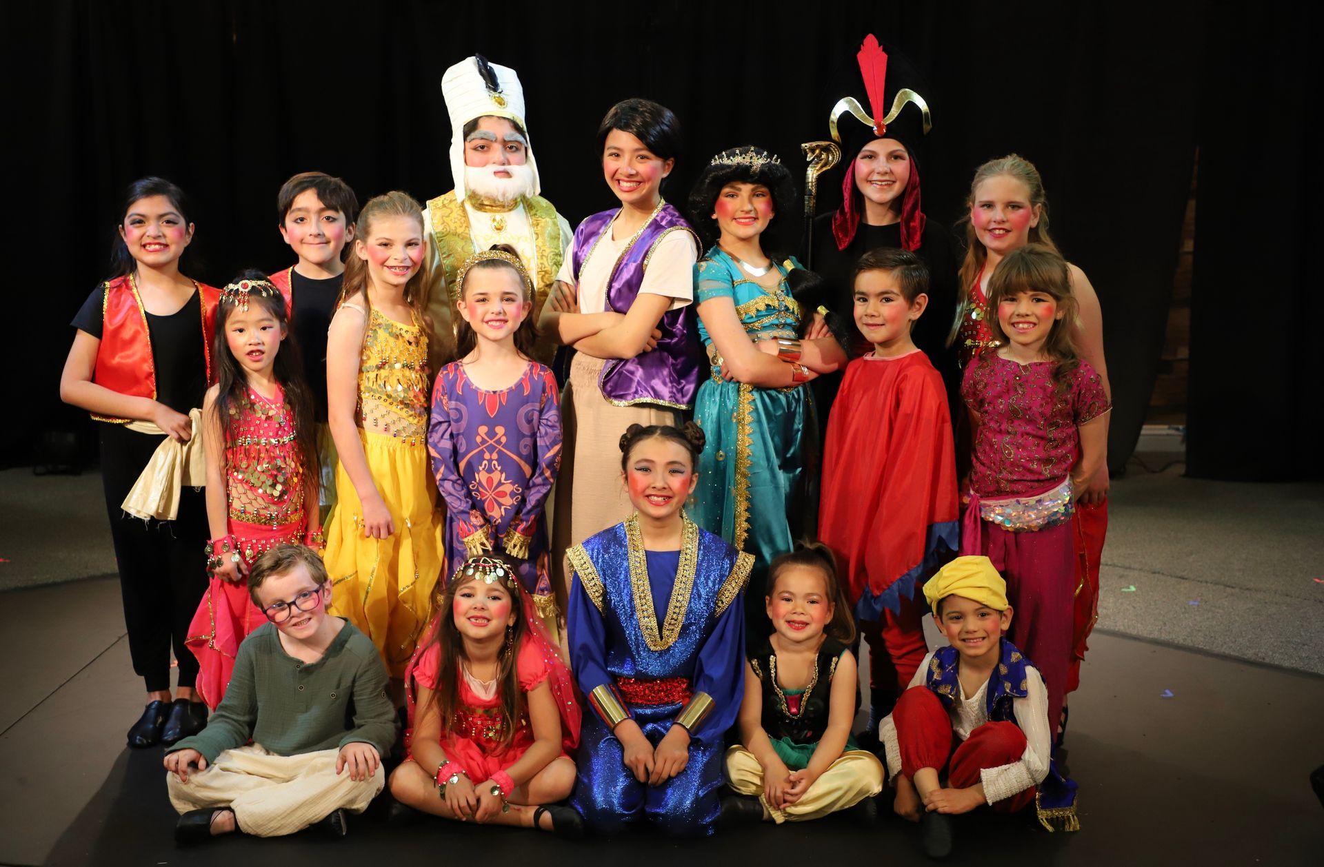 A group of children dressed in costumes are posing for a picture.