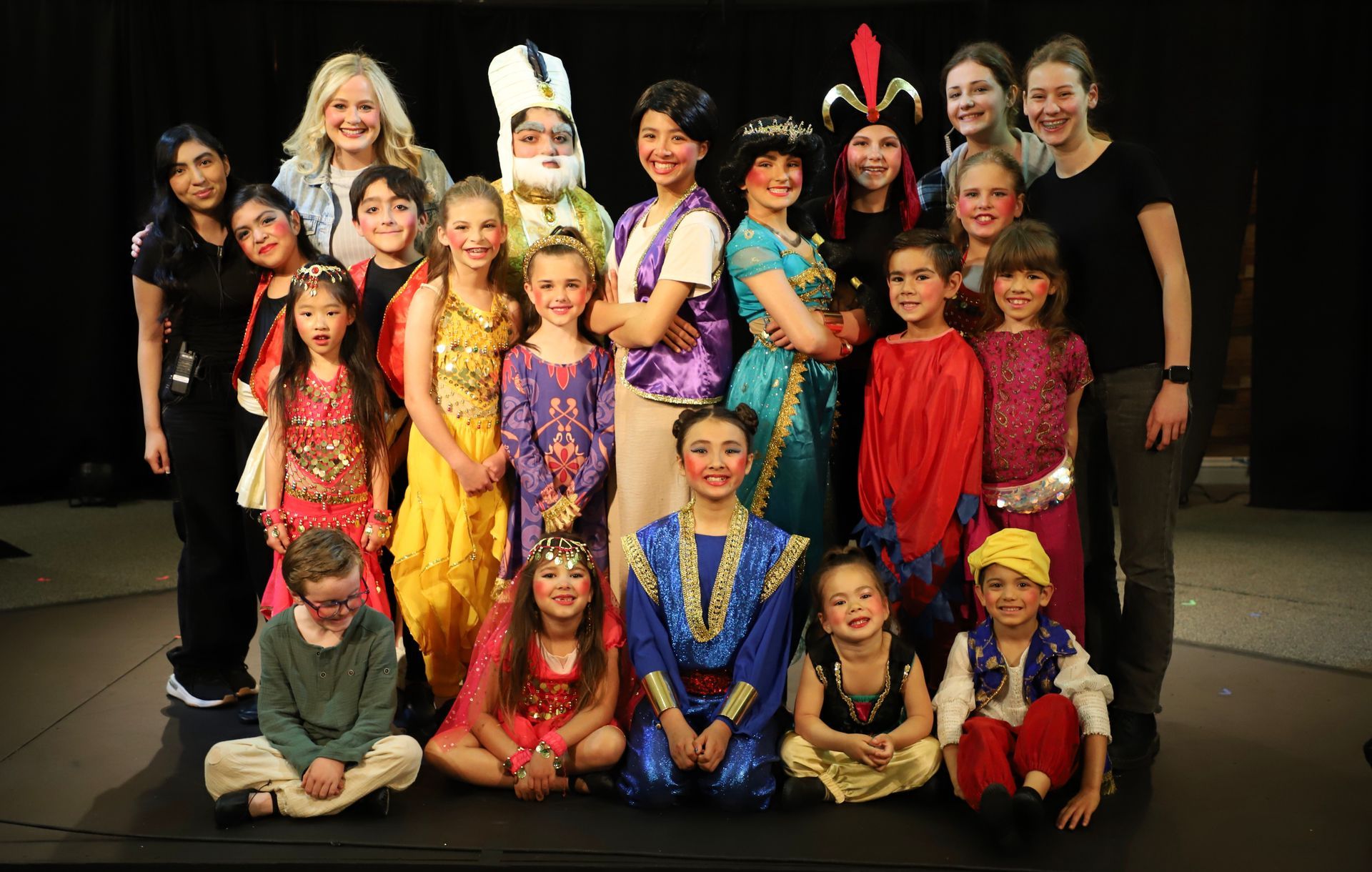 A group of children dressed in costumes are posing for a picture.