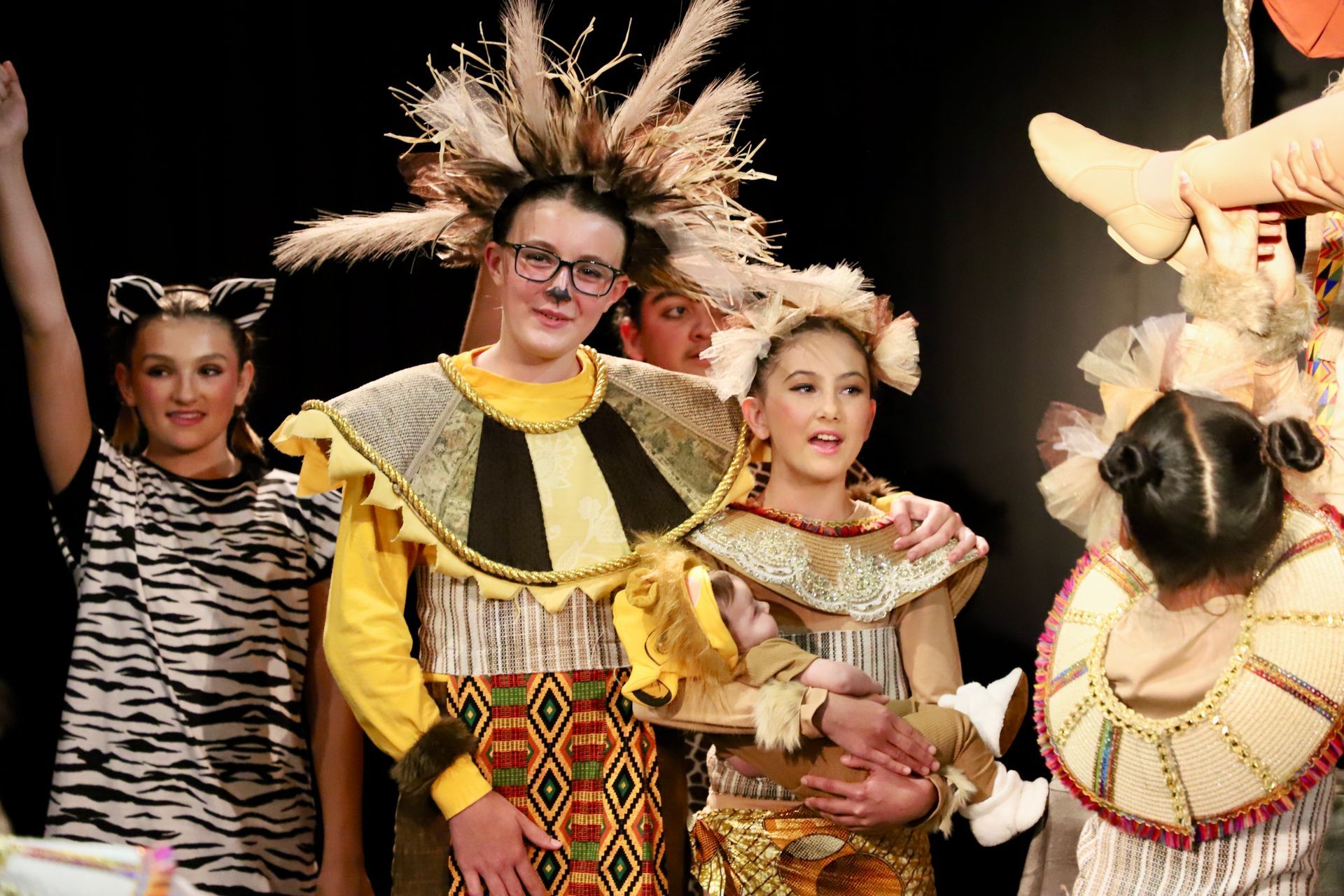 A group of people in costumes are standing next to each other on a stage.