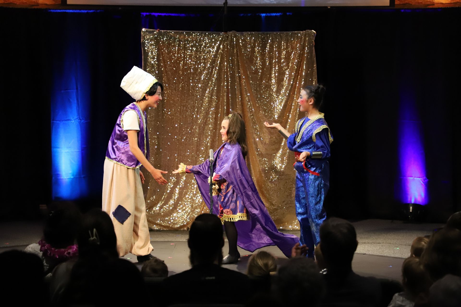 A group of people are standing on a stage in front of a crowd.