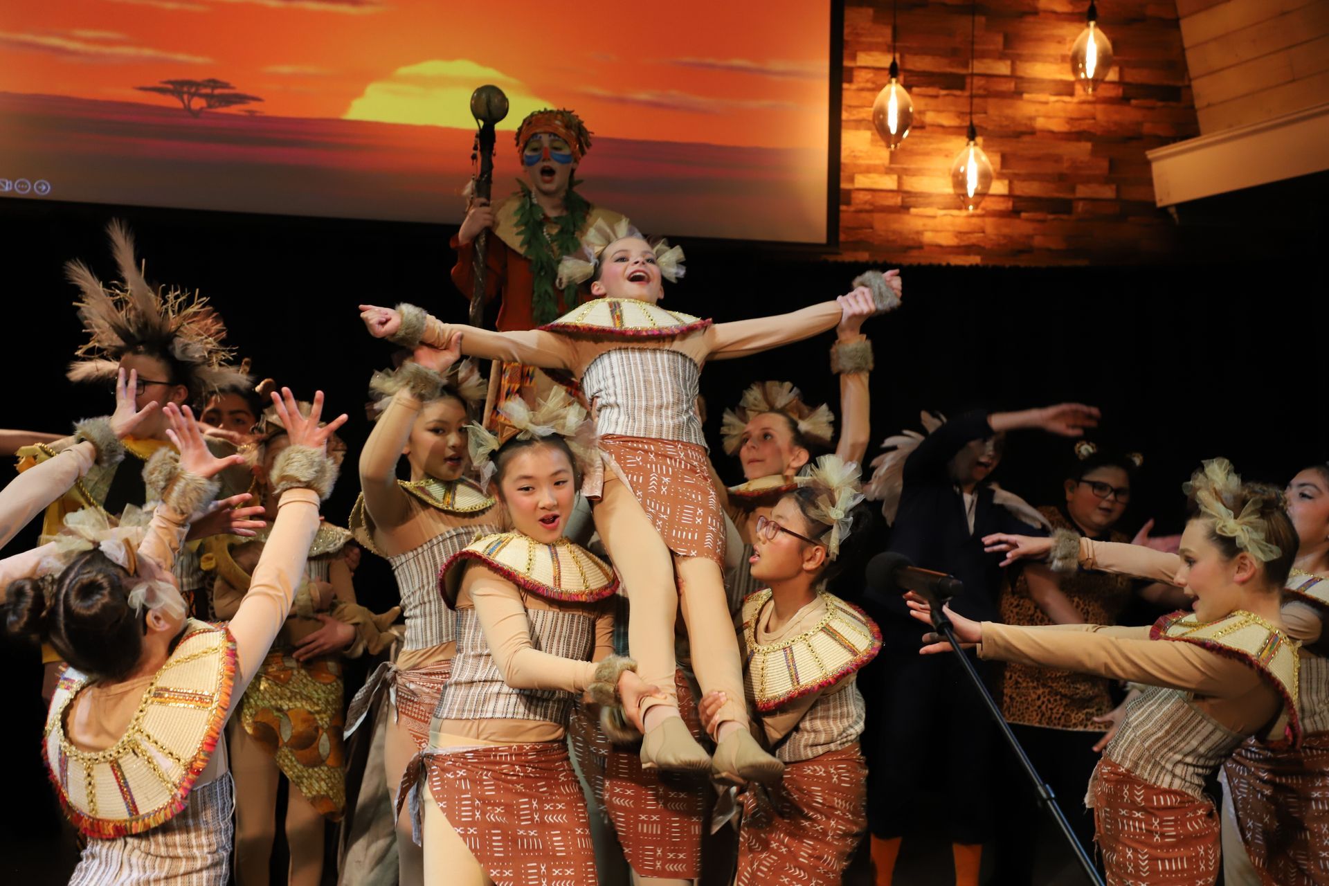 A group of people in costume are dancing on a stage.