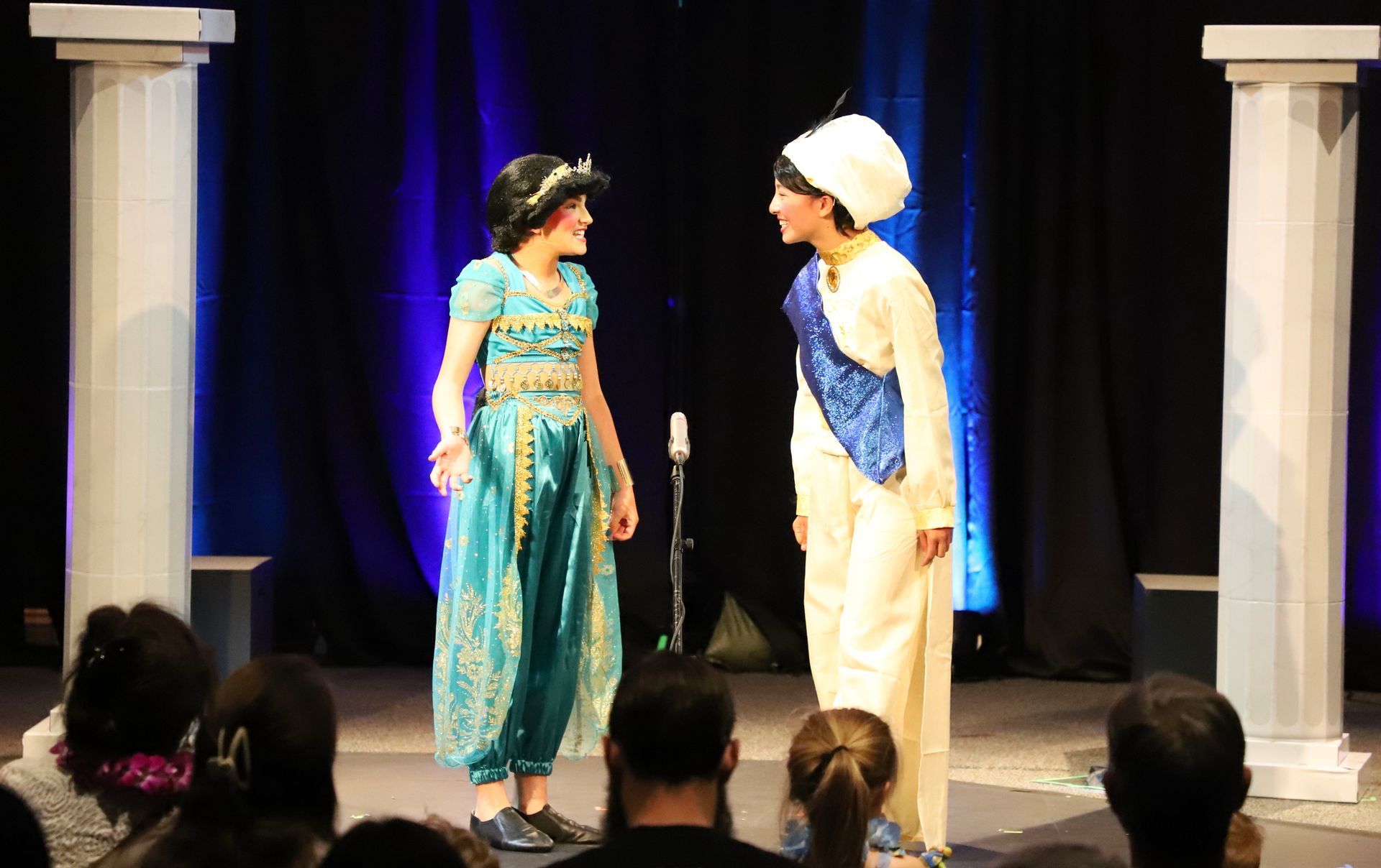 A man and a woman are standing next to each other on a stage.