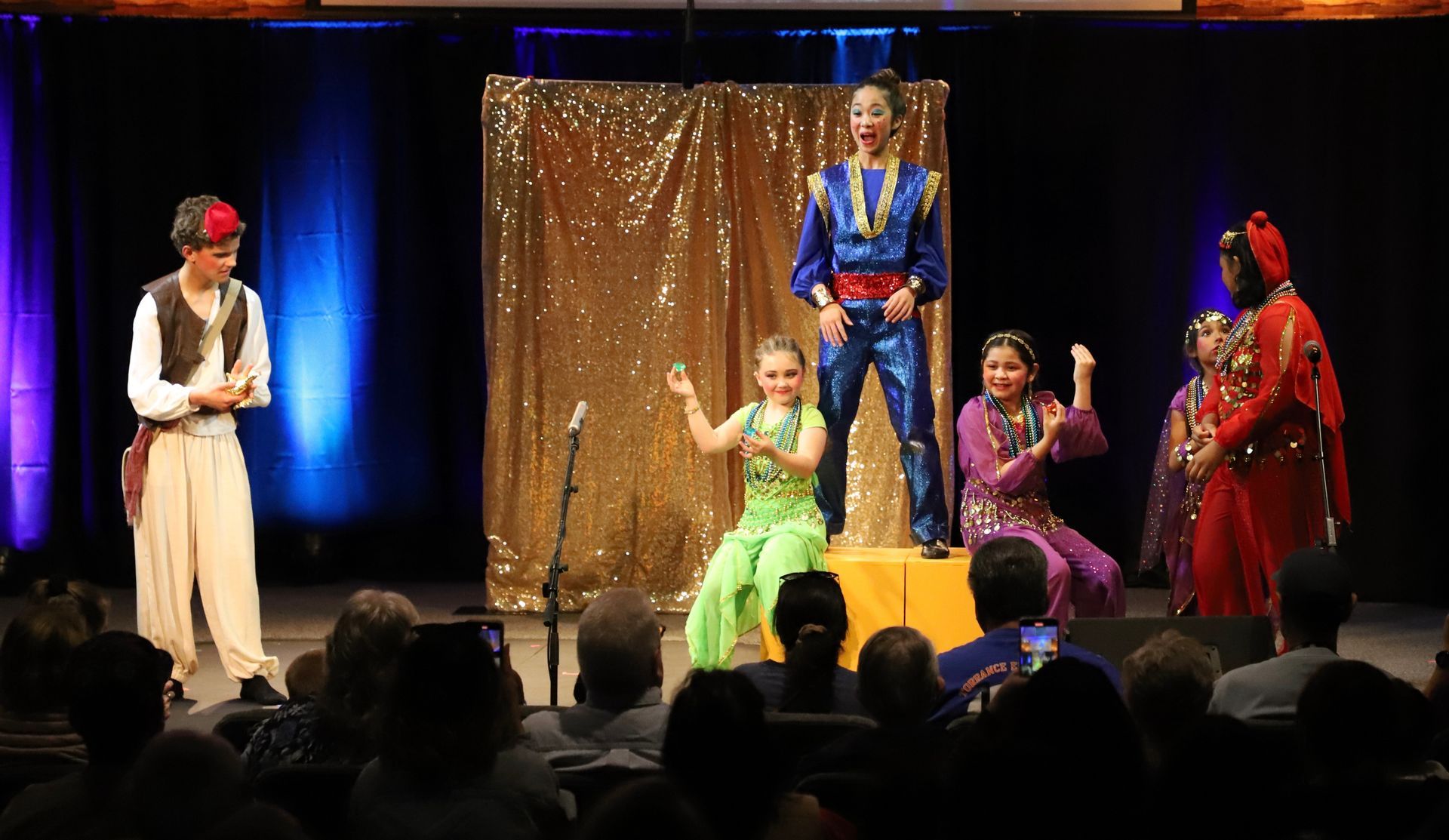 A group of people are standing on a stage in front of a crowd.