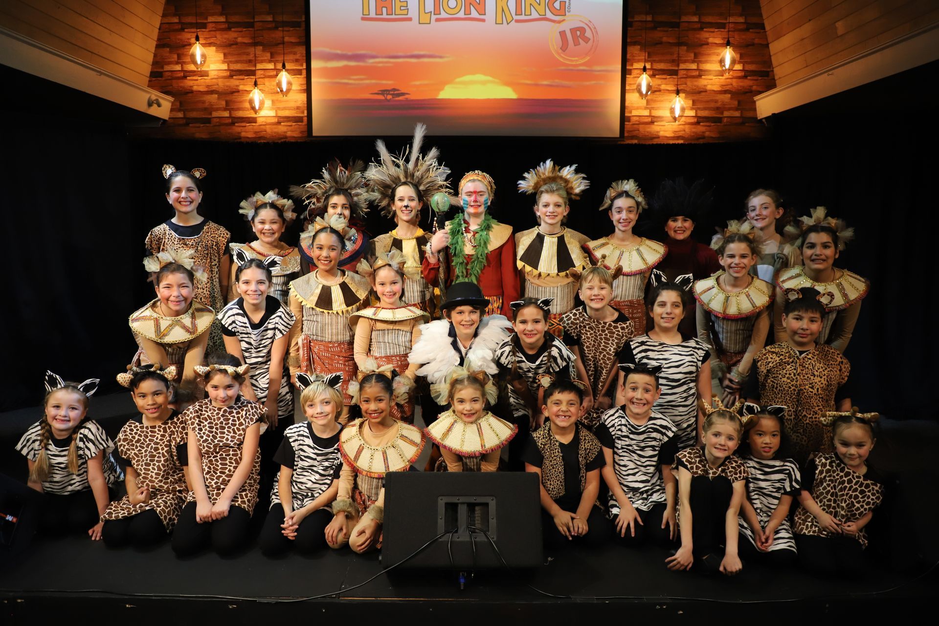 A group of children are posing for a picture on a stage