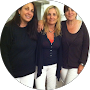 Three women are posing for a picture together in a circle.