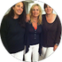 Three women are posing for a picture together in a circle.