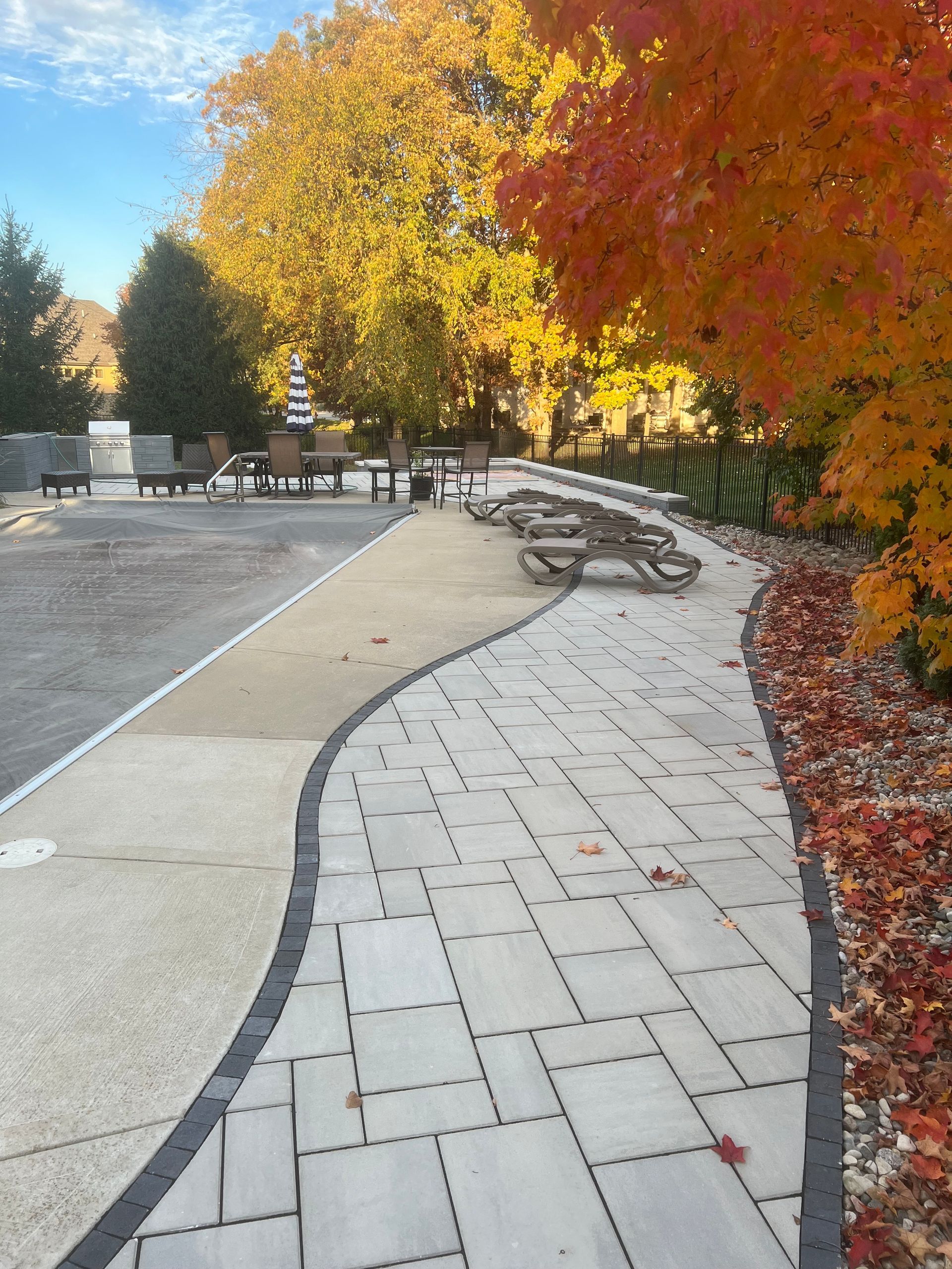 Pathway lined with picnic tables and fall foliage.