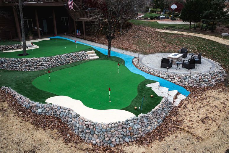 Stone patio with brick wall and blue sky.