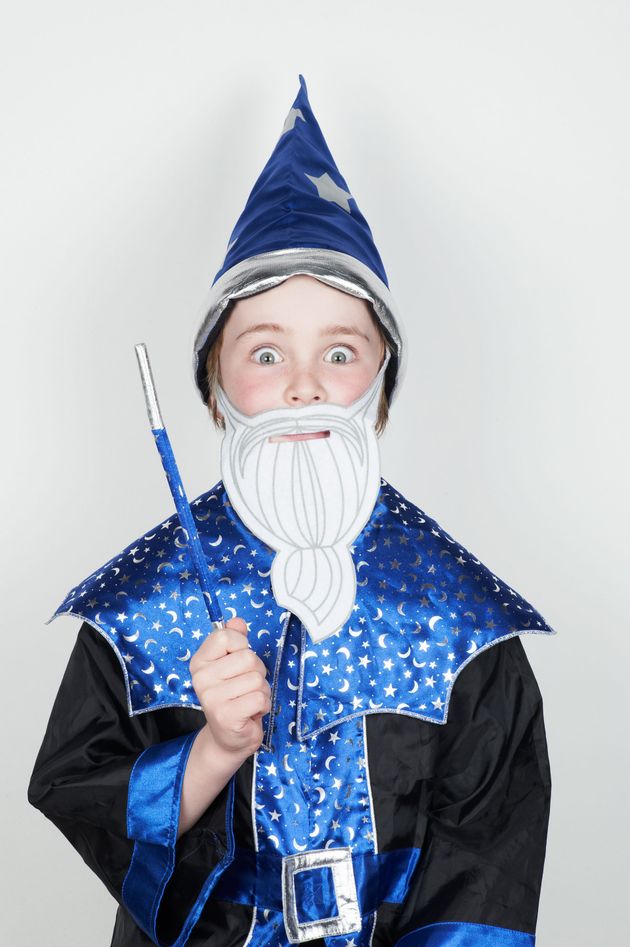 Un ragazzino in costume da mago tiene in mano una bacchetta