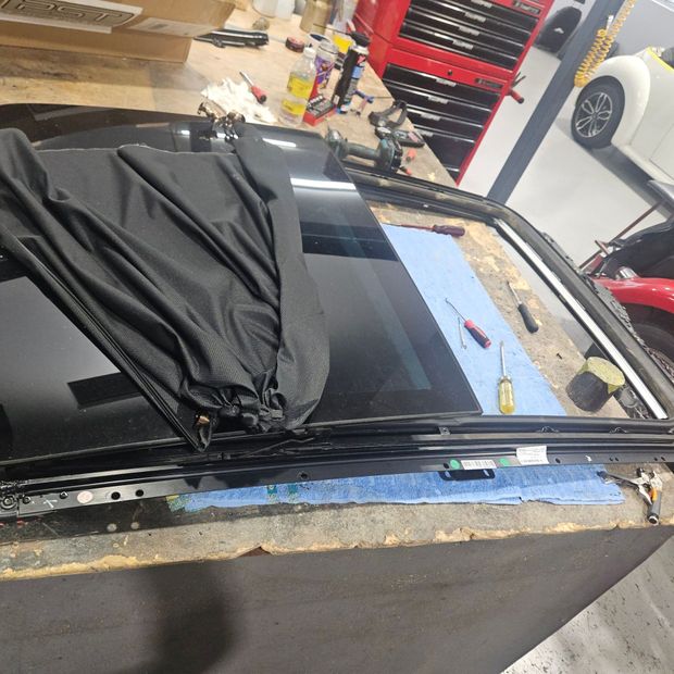 The roof of a car is being repaired in a garage