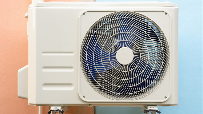 A white air conditioner is mounted on a wall.