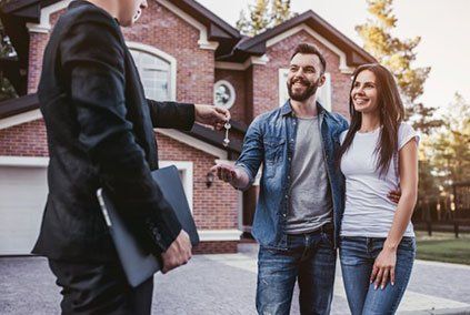 Interest Rate — Happy Couple Taking Keys From Real Estate Agent in Costa Mesa, CA