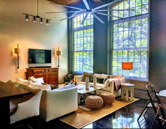 A living room with a lot of furniture and a ceiling fan