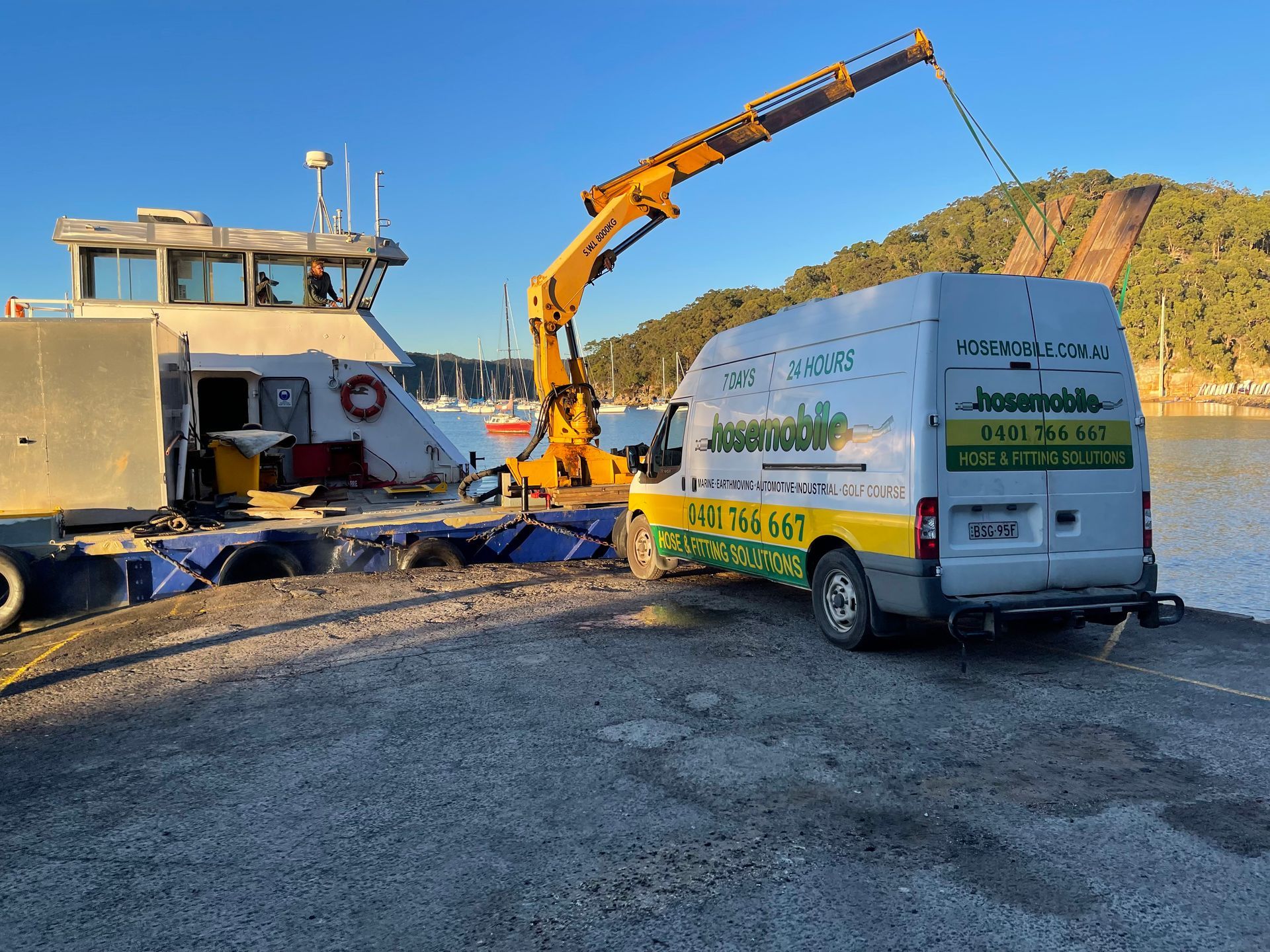 A white van is parked next to a boat with a crane attached to it — Hosemobile In Kariong, NSW