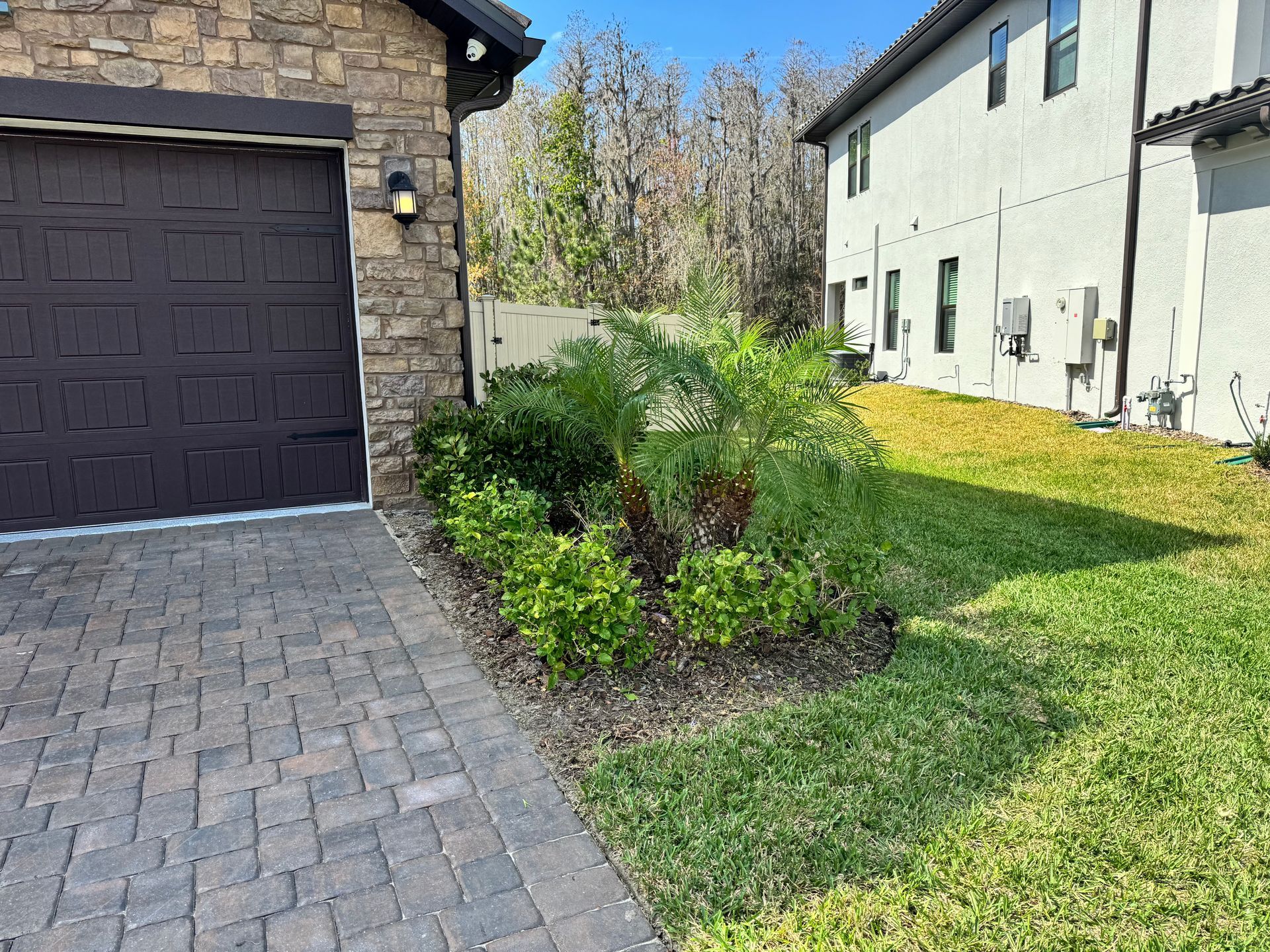 A brick driveway leading to a garage and a house.