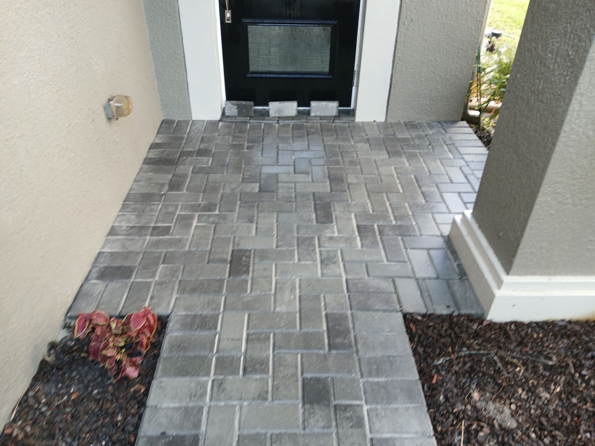 A brick walkway leading to the front door of a house