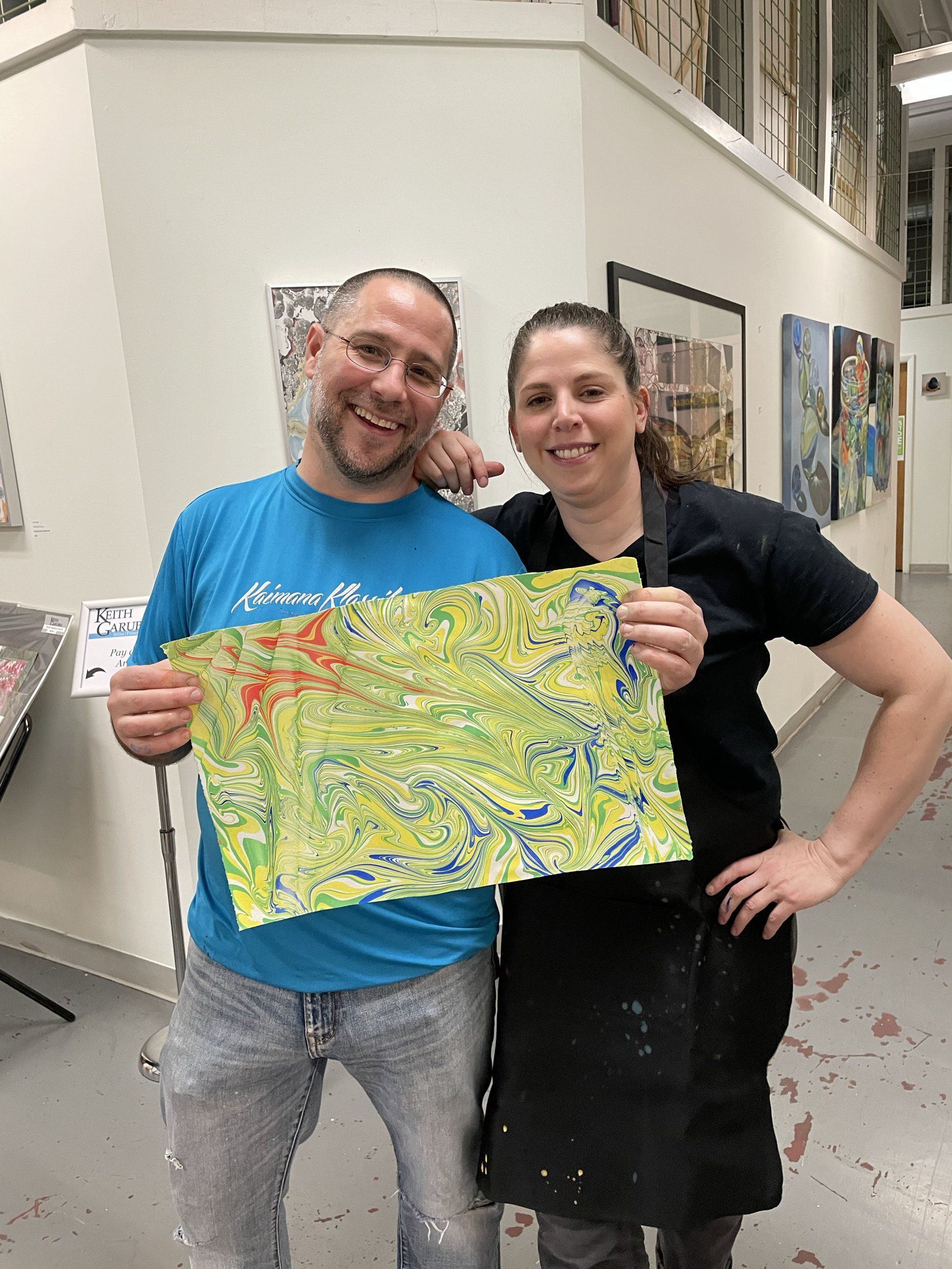 A couple enjoys their own work at The Paper Marbling Experience.