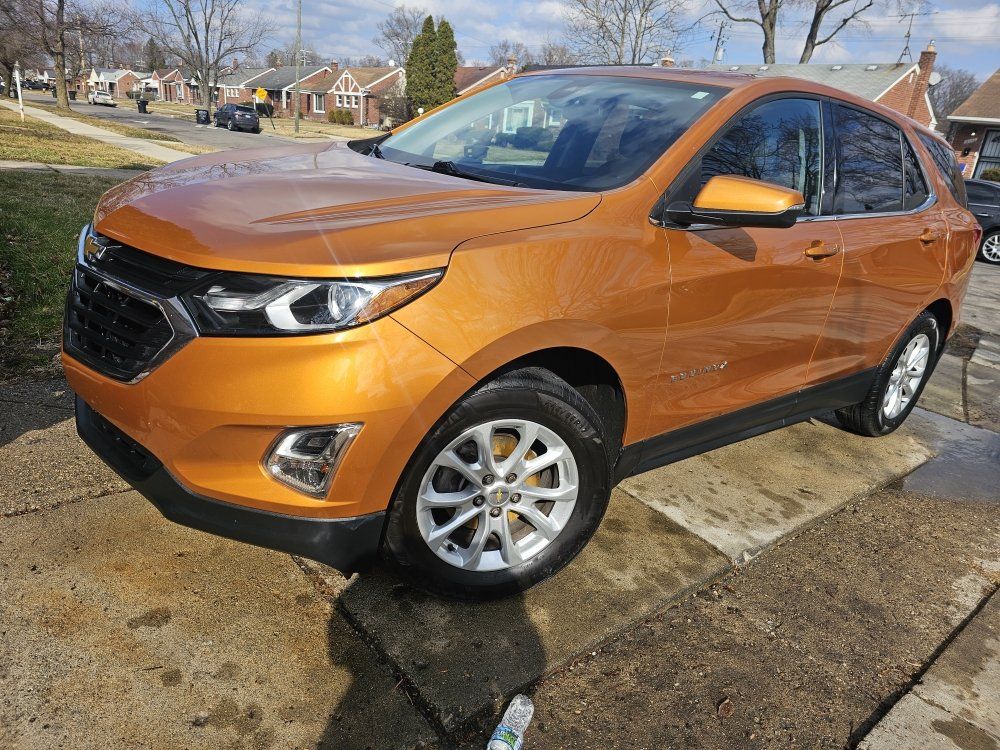 Golden-orange Chevrolet Equinox parked on a concrete surface.  Daytime, residential setting.
