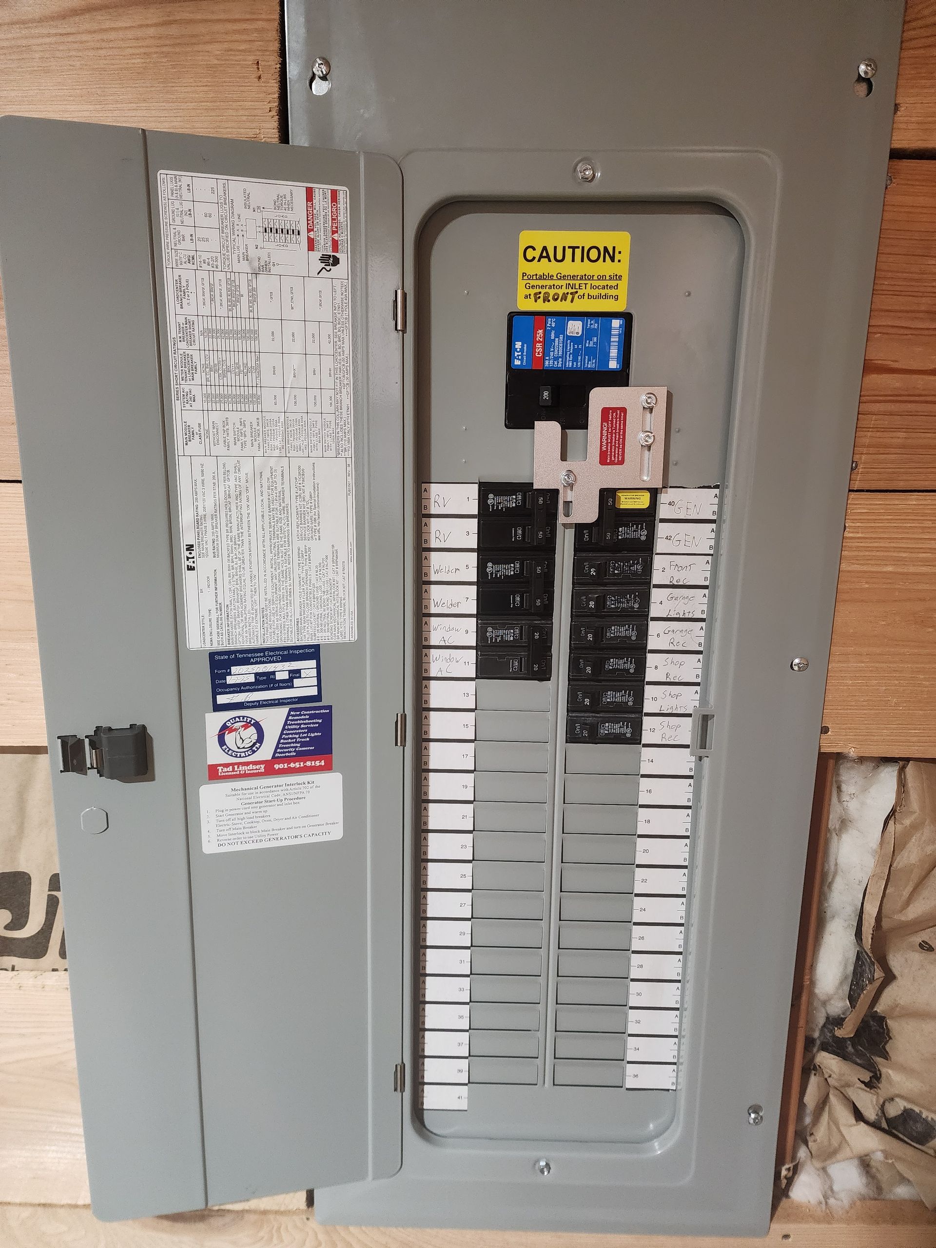 Electrical circuit breaker panel with door open, revealing multiple switches.