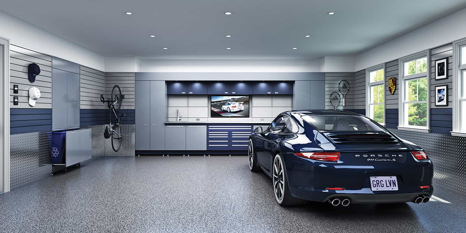 A modern, well-organized garage featuring a blue Porsche and custom cabinetry. The space has metallic accent walls, recessed lighting, and a TV.