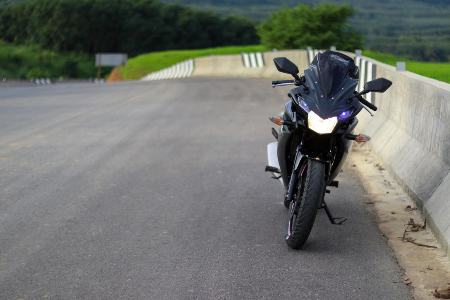 A black motorcycle is parked on the side of a road.