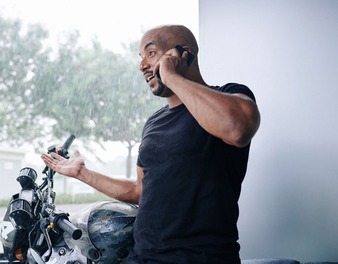 A man is sitting on a motorcycle talking on a cell phone.