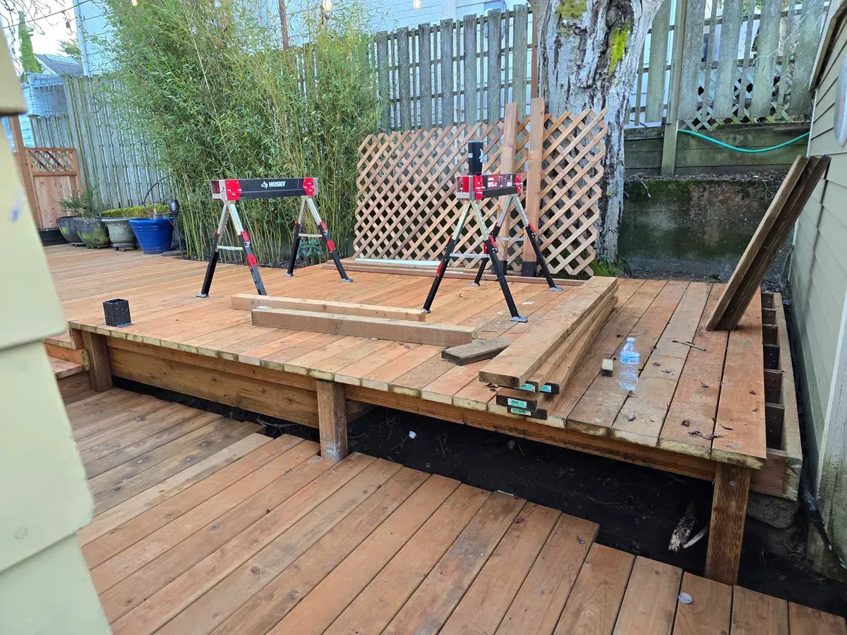 A wooden deck is being built in a backyard.