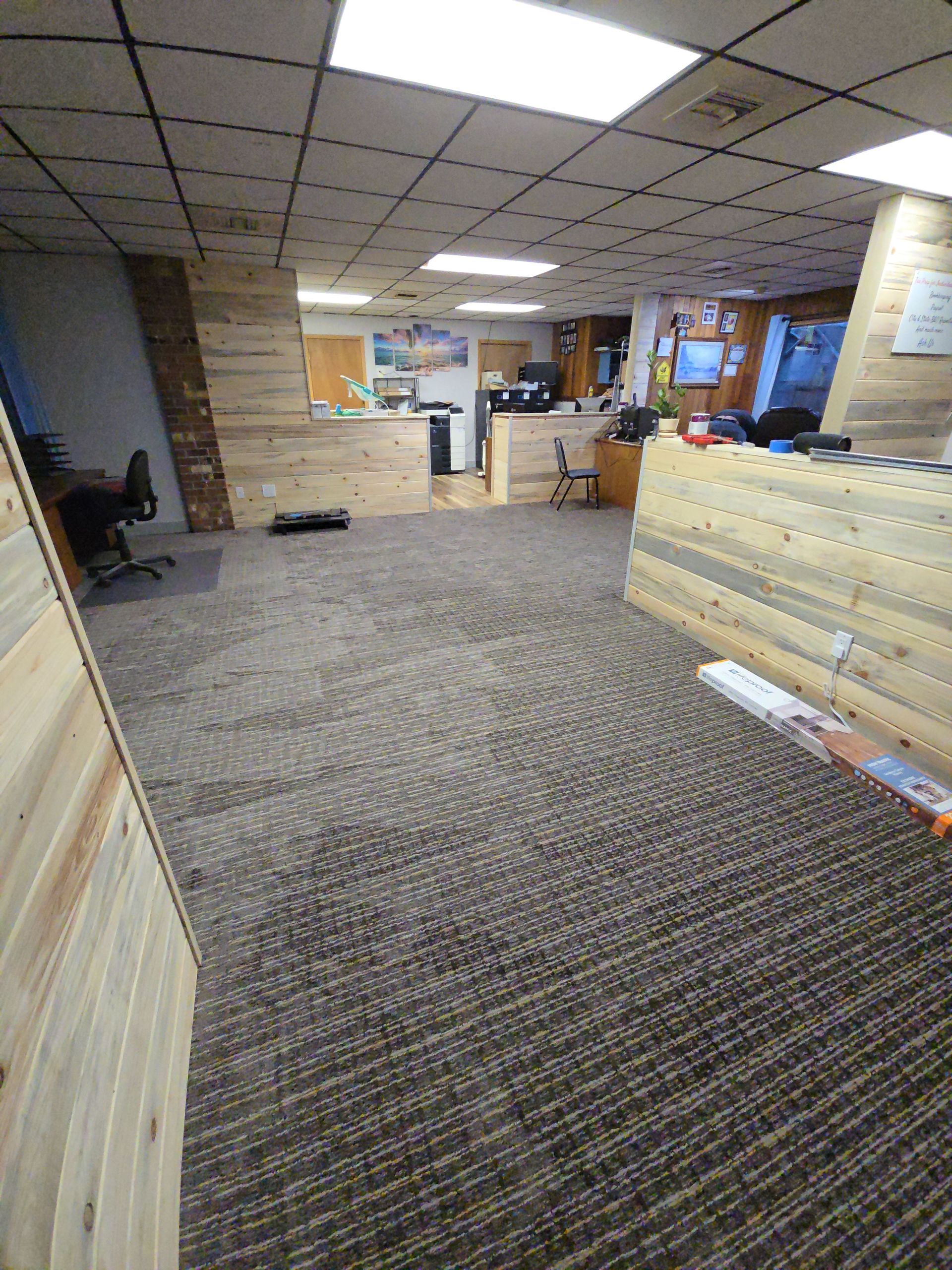 A large room with a carpeted floor and wooden walls.