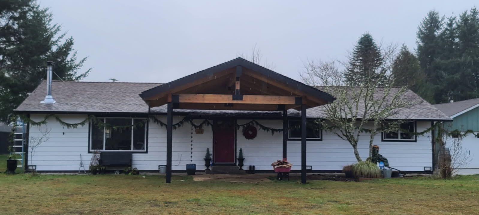 A white house with a porch decorated for christmas