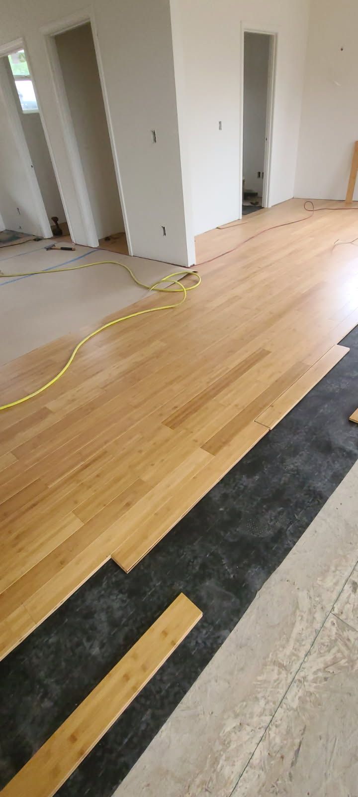A wooden floor is being installed in a room.
