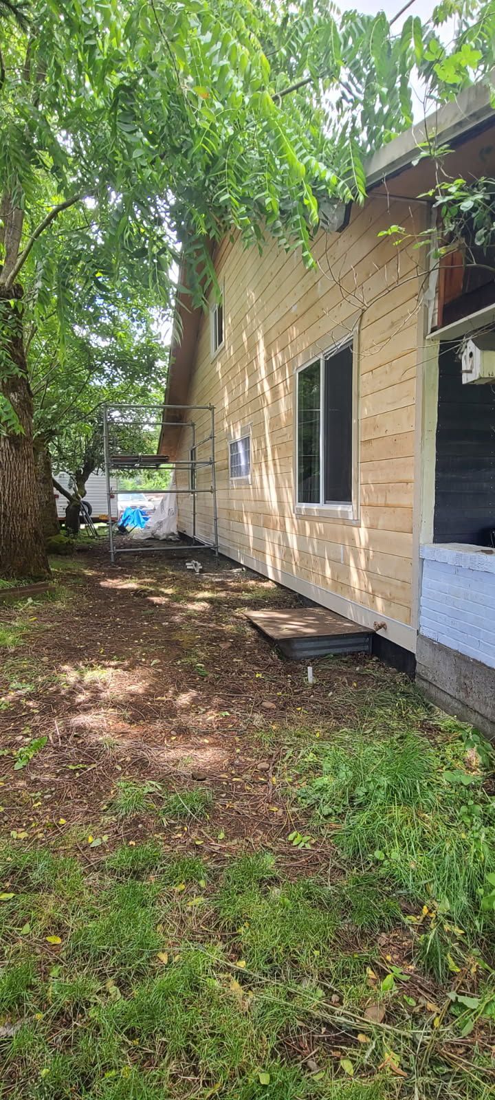 The backyard of a house with a lot of grass and trees.
