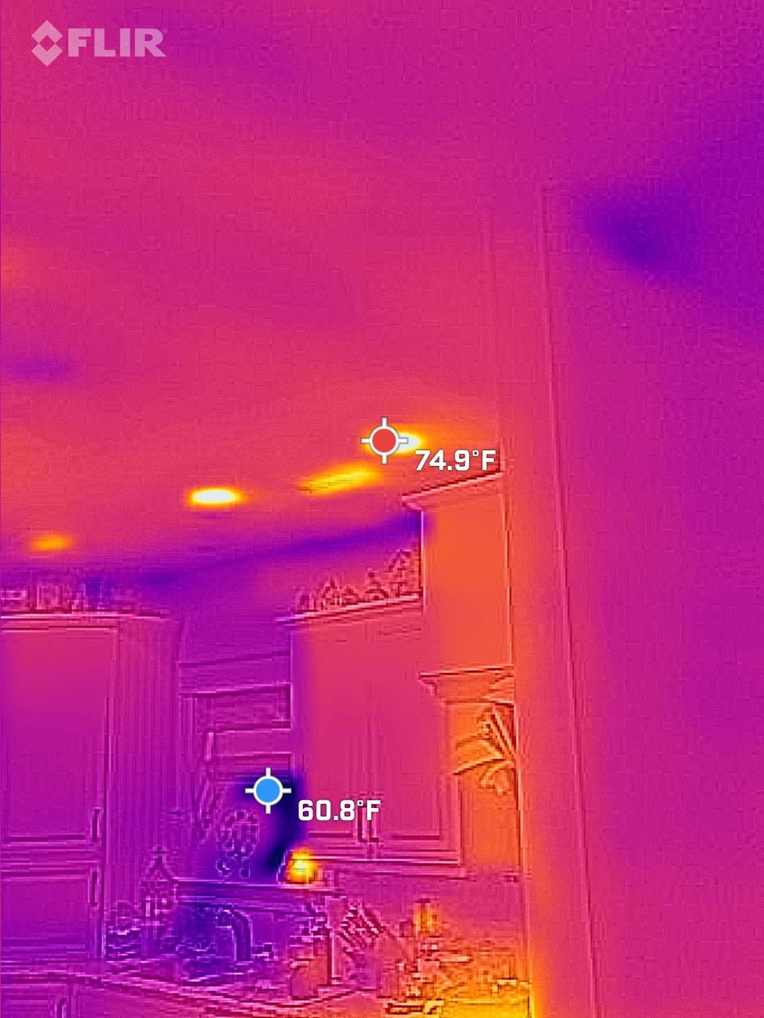 Thermal view of a kitchen interior with cabinets, countertops, and temperature readings visible.