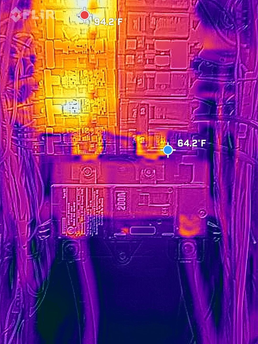 Thermal image of a circuit board with a bright hot area near the center and cooler purple edges