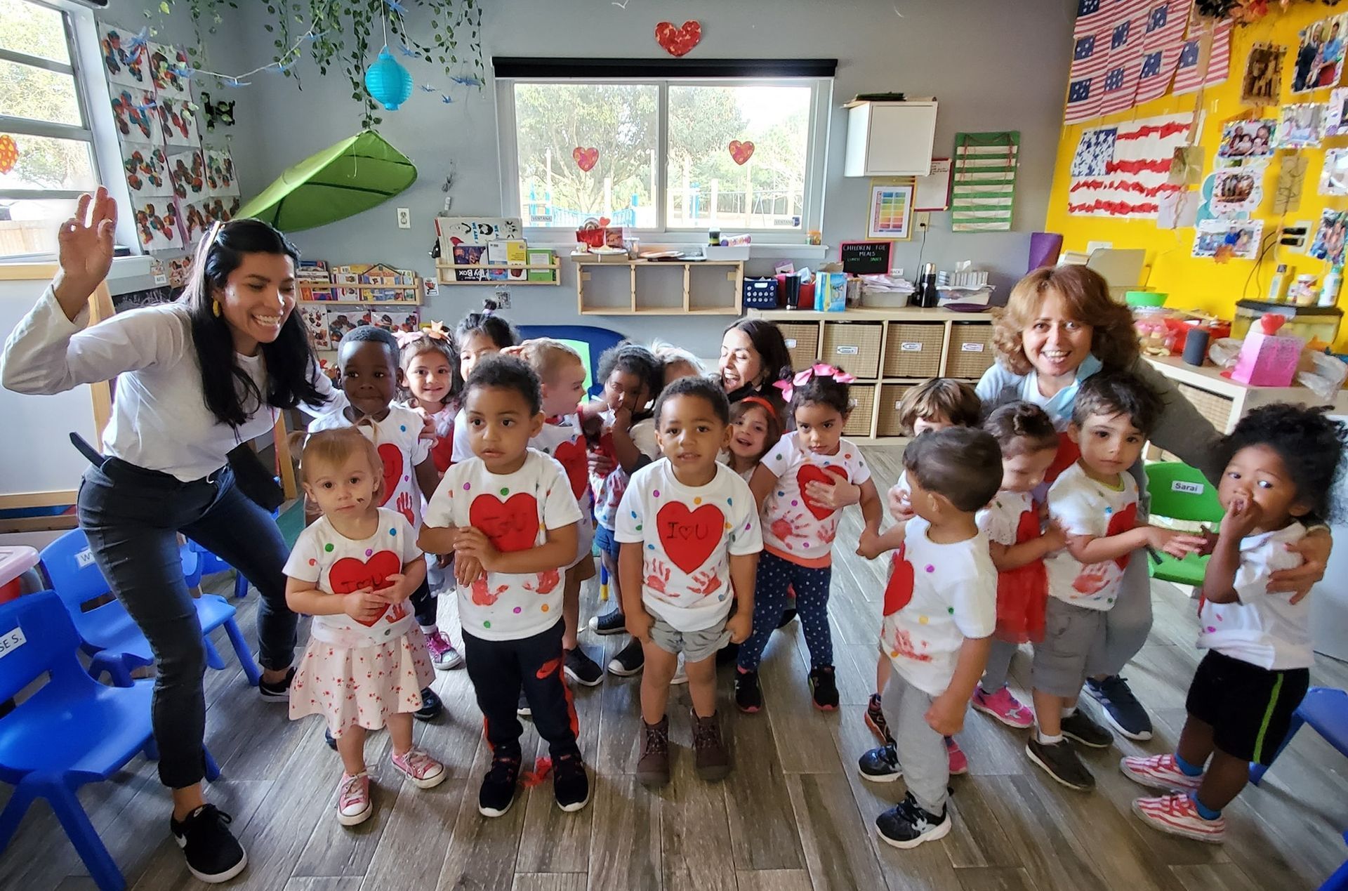 A woman is standing in front of a group of children in a classroom.