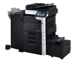 A black and silver printer is sitting on top of a black box on a white background.