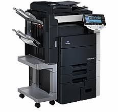 A black and white photocopier is sitting on top of a cart on a white background.