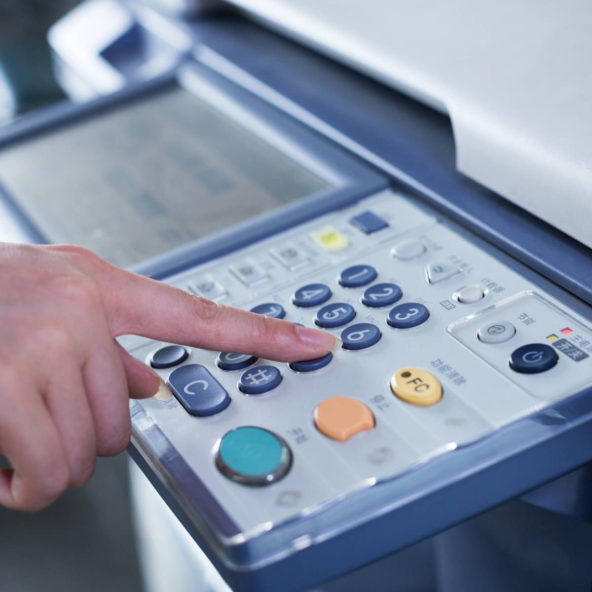 A person is pressing the c button on a printer
