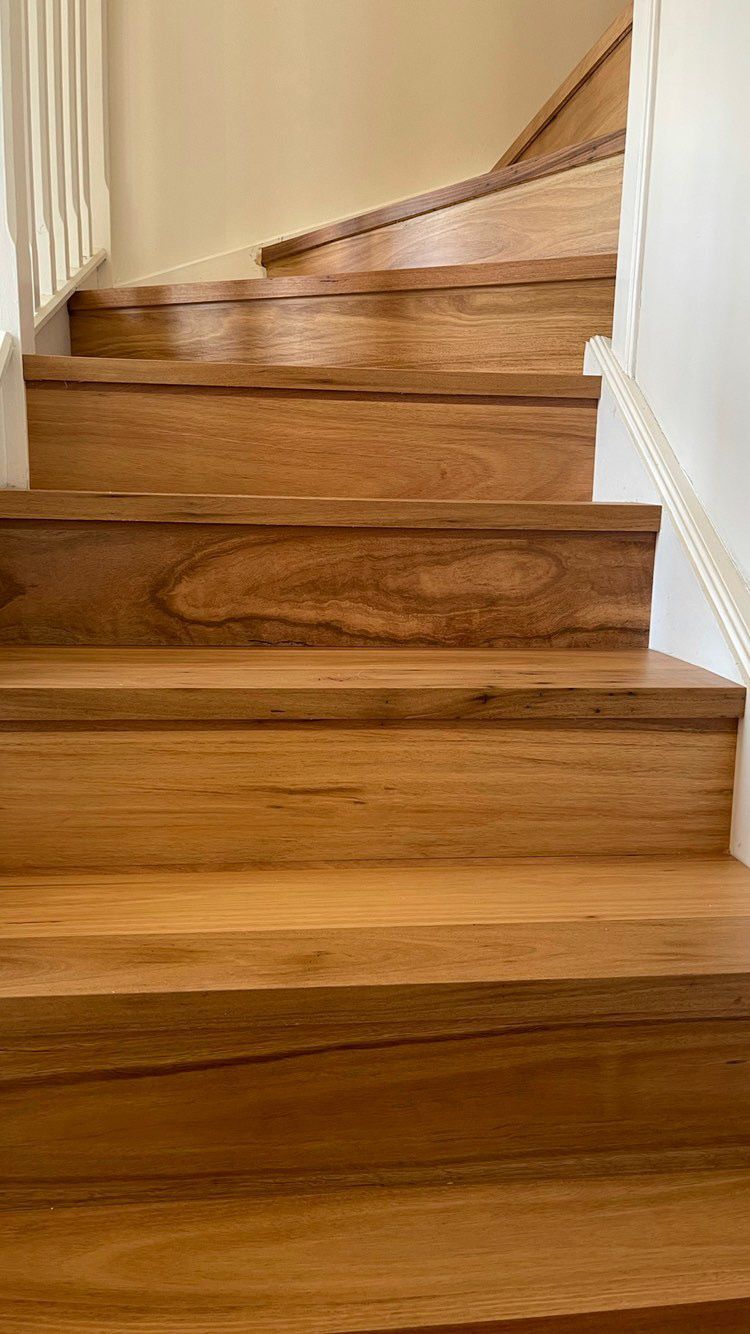 A close up of a staircase with a white railing.