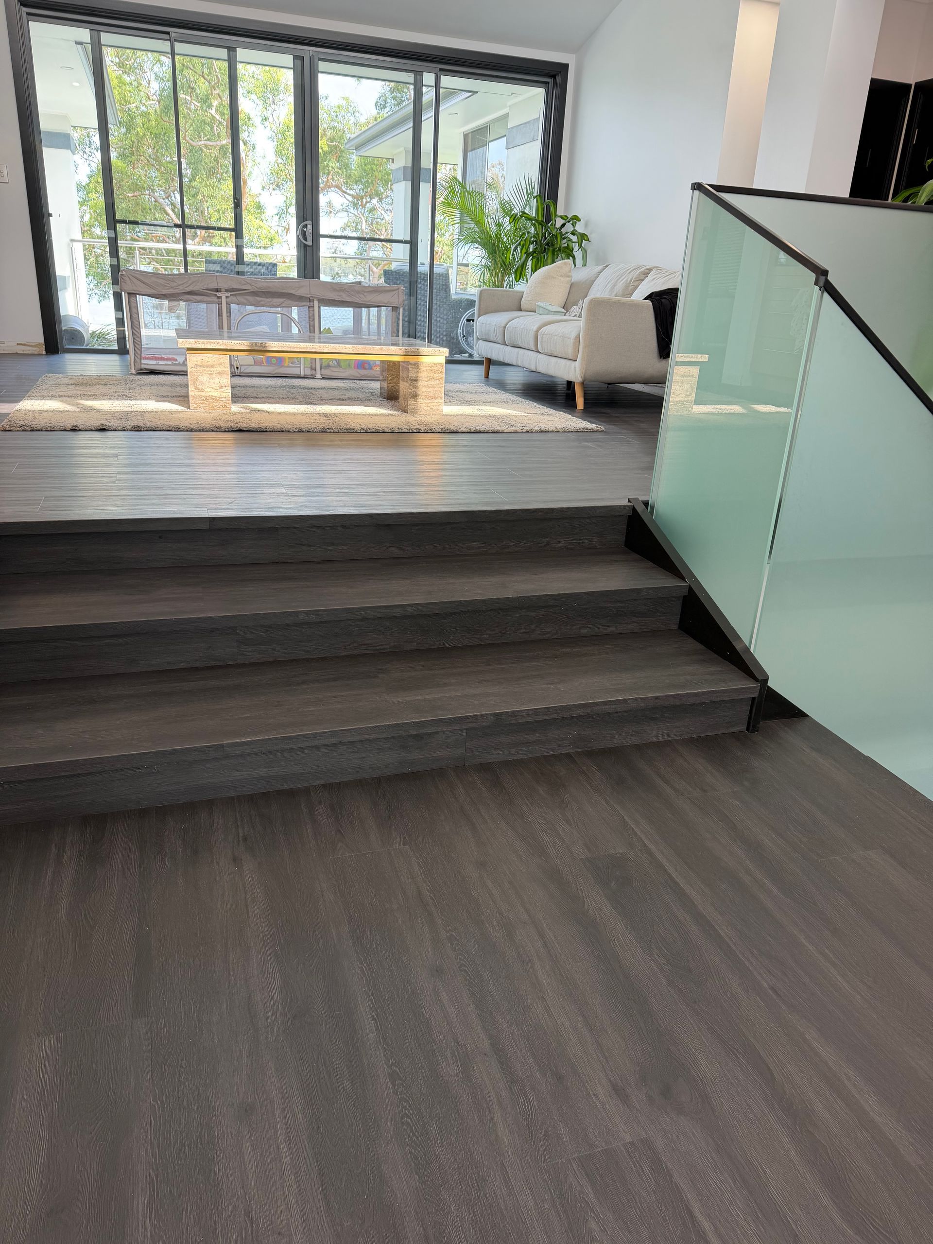 Wooden staircase with geometric pattern, white trim, viewed from above.
