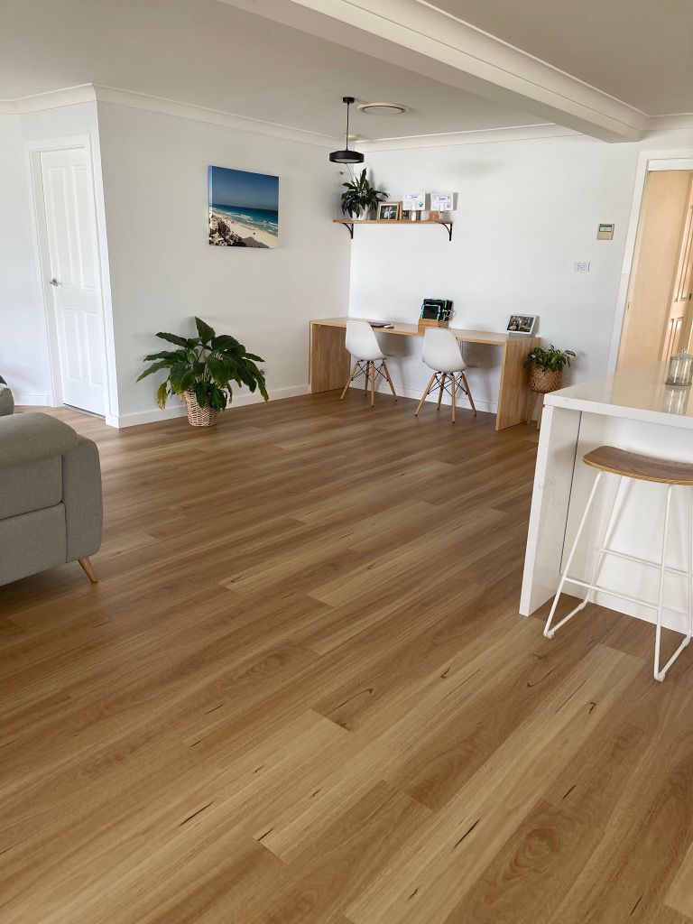 A living room with hardwood floors with computer table