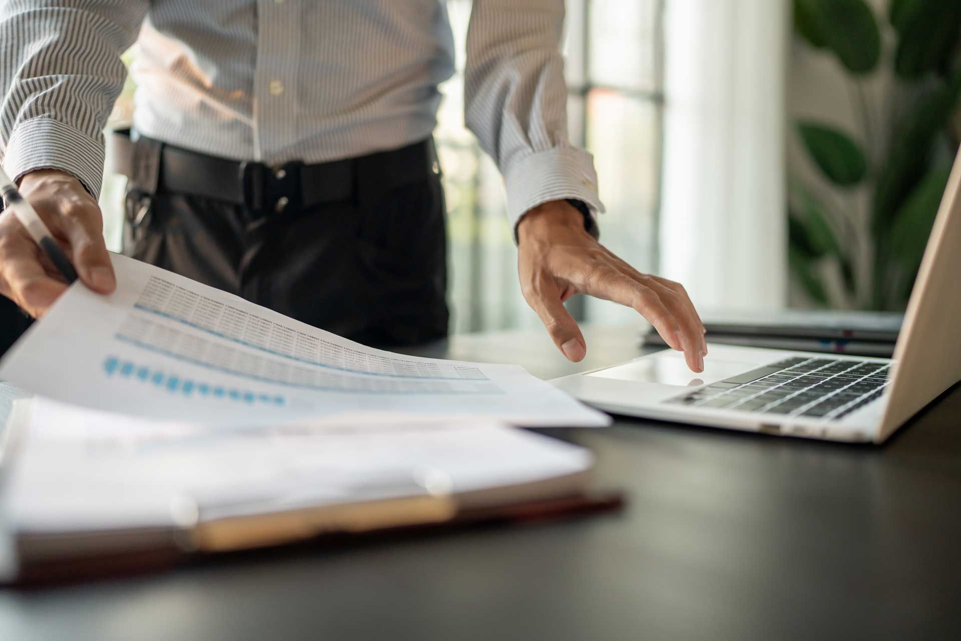 Kvinde og mand gennemgår dokument, smilende kvinde, siddende ved bord med krus.