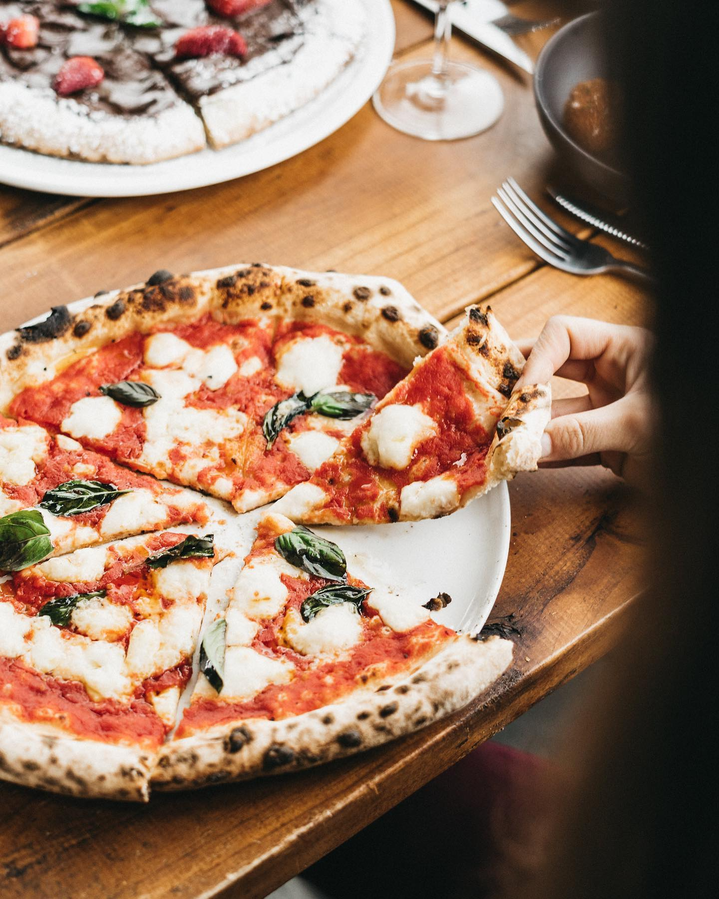 a hand take pizza at Il Caminetto