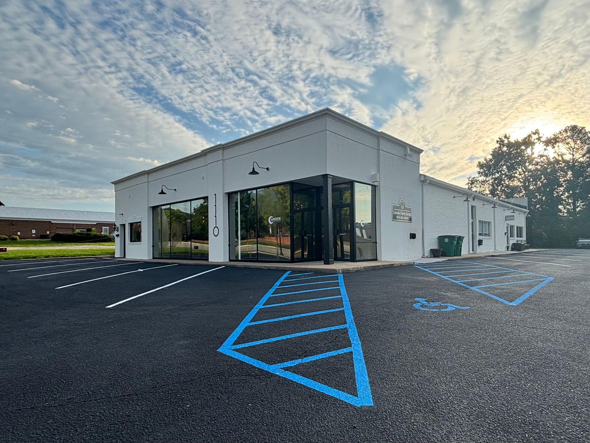 A white building with a handicapped parking space in front of it.