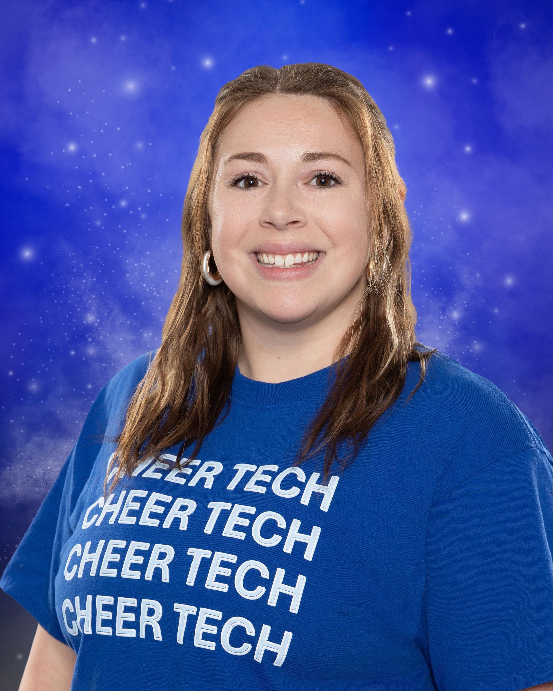 A woman is wearing a blue t-shirt that says cheer tech.