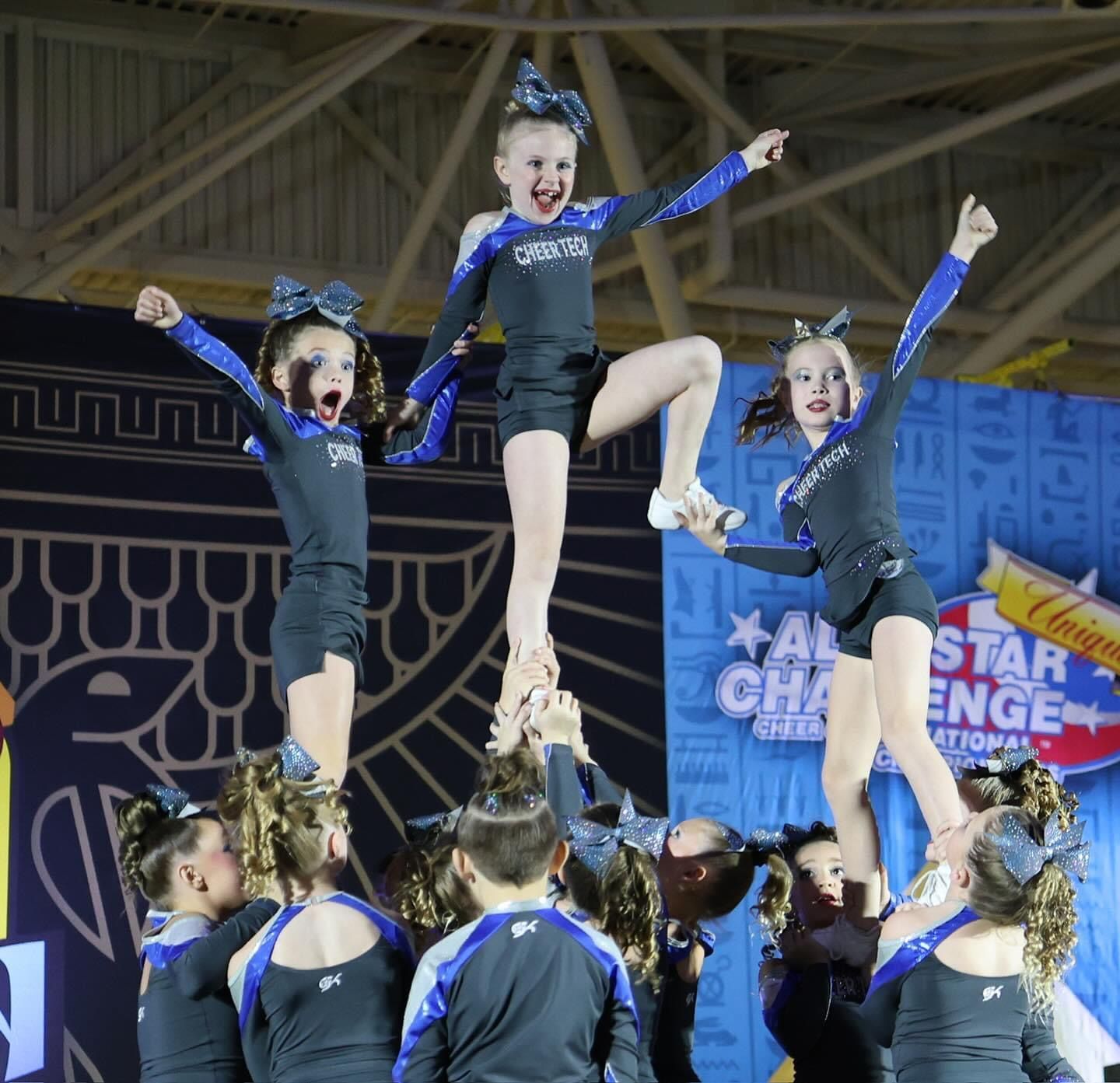 A group of cheerleaders are performing in front of a banner that says star challenge