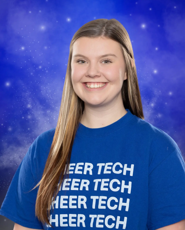 A girl wearing a blue shirt that says cheer tech