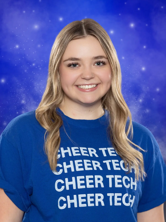 A girl wearing a blue shirt that says cheer tech