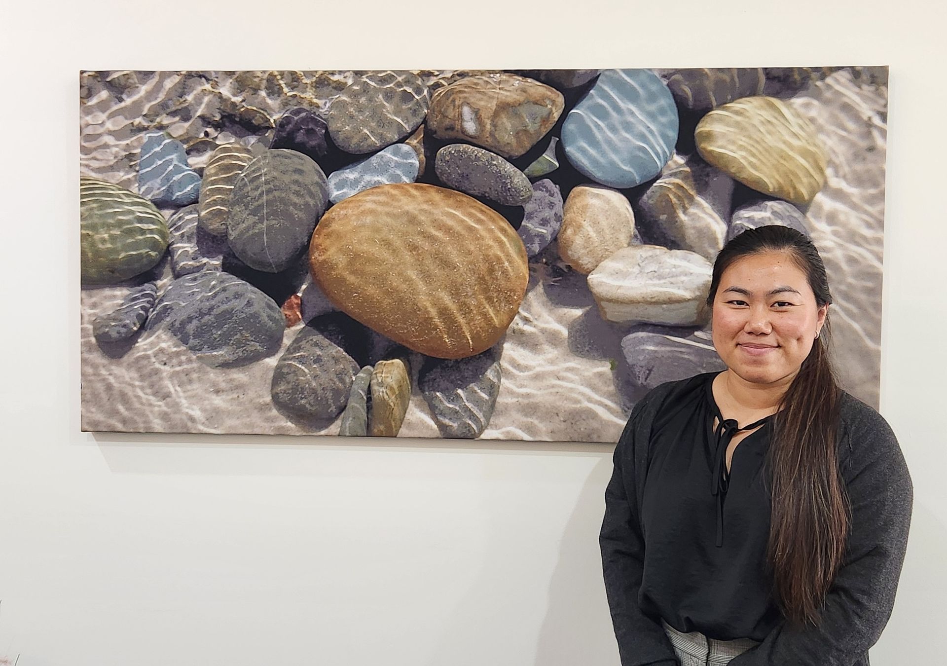 A Woman Is Standing Infront Of a Picture on a wall— Adding Value CFO Pty Ltd in Larrakeyah, NT
